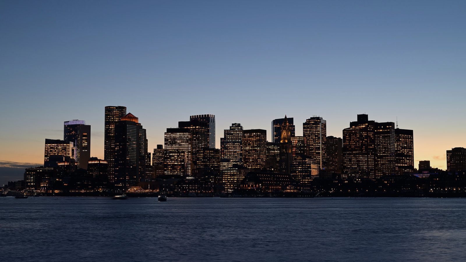 Boston's skyline across the harbour at dusk