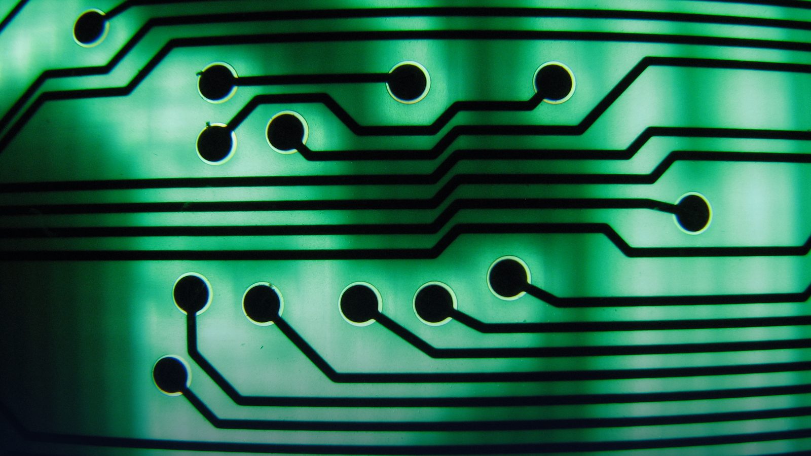 A close-up of traces on a green circuit board