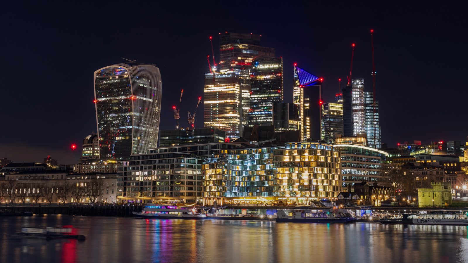 City of London skyscrapers reflected in the Thames at night