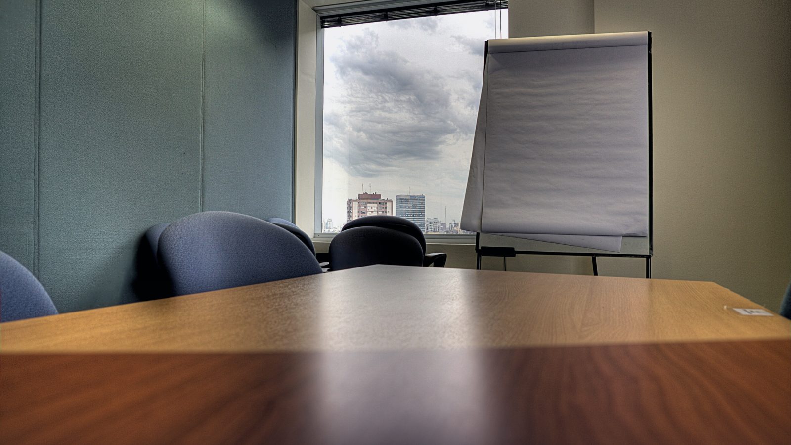 An empty meeting room with a table and flip chart