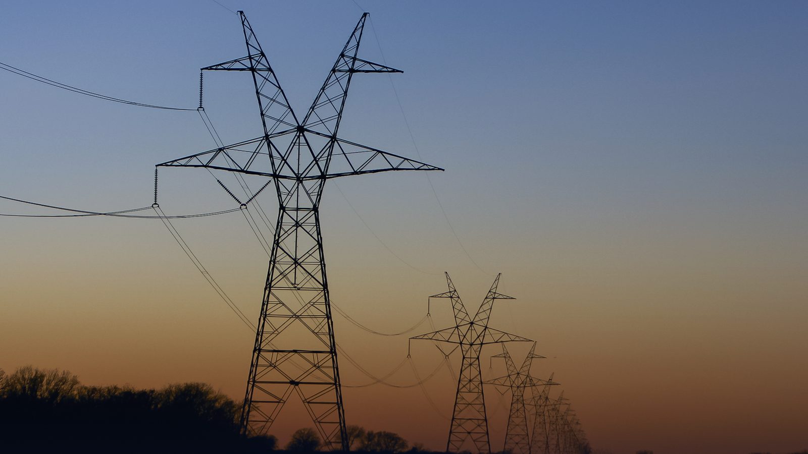 Electricity transmission towers silhouetted at sunset in East Texas